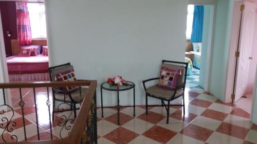 a living room with two chairs and a table at Fayruz Villa is a 3 bedroom, 3 bathroom detached house with AC and swimming pool 5 minutes walk from Flic en Flac public beach in Flic-en-Flac