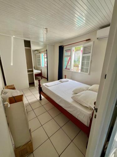 a bedroom with a large bed and a window at Maison Belle Vue in Le Robert