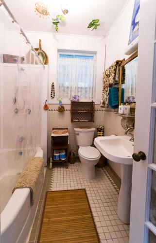 a bathroom with a toilet and a tub and a sink at Hale Kawehi BnB Guesthouse in Hilo