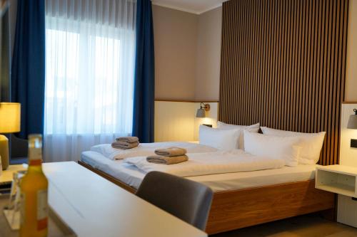 a bedroom with a bed with towels on it at Hotel Seebrise Grömitz in Grömitz