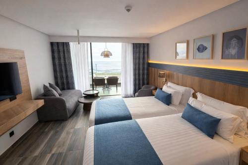 a hotel room with two beds and a television at Taghazout Palm Hotel in Taghazout