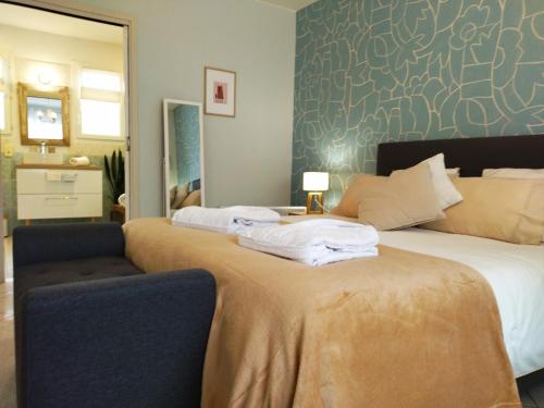 a bedroom with two beds and a chair and a mirror at Fleurs de Cosmos, suite lumineuse climatisée in Albi