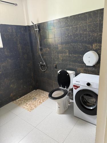 a bathroom with a toilet and a washing machine at Chez Charline in Saint-Claude