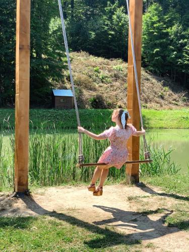 a young girl is riding on a swing at Orlyne Gnizdo in Chernivtsi