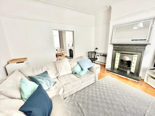 a living room with a white couch and a fireplace at New Brighton Beach in Wallasey