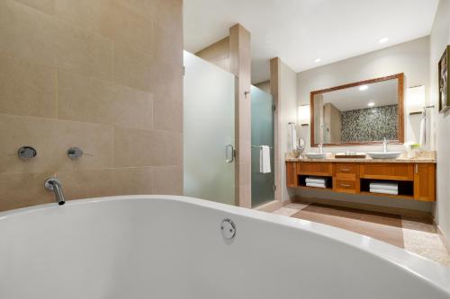 a bathroom with a tub and a sink and a mirror at Hyatt Vacation Club at Ka'anapali Beach in Lahaina