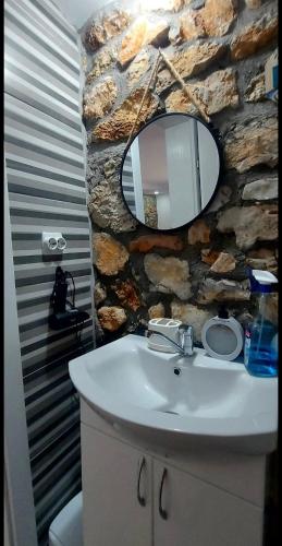 a bathroom with a sink and a stone wall at Guest House Nadol SUP and Bikes included in Ohrid