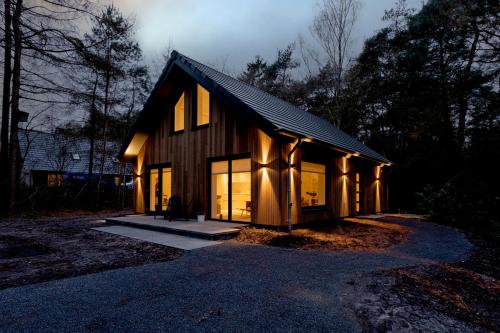 a house with its lights on in the woods at Casa Allocco in Norg