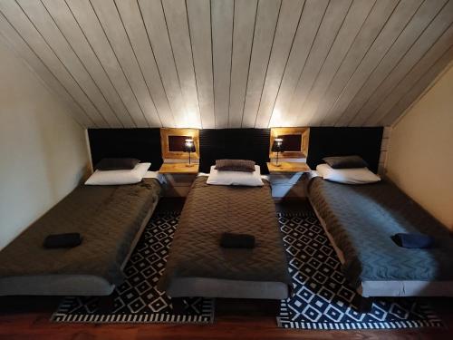 two beds in a room with a ceiling at Wilcze Schronisko in Czerniki