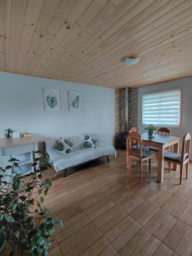 a living room with a bed and a table and chairs at Cabaña Aeropuerto el Tepual in Puerto Montt