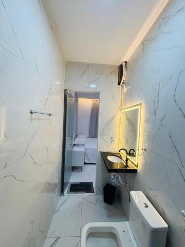 a white bathroom with a sink and a toilet at Flats Sucesso in Teresina