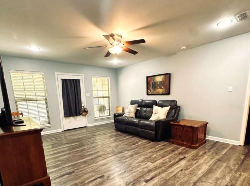 a living room with a couch and a ceiling fan at Mendoza Villa - Longview Tx in Longview