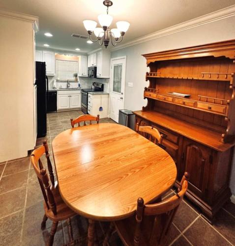 a wooden table in a kitchen with a piano at Mendoza Villa - Longview Tx in Longview