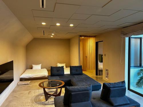 a room with a bed and a table and chairs at ERUMAYA Resort in Motobu