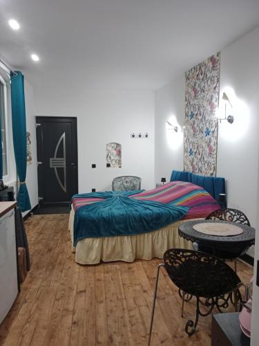 a bedroom with a bed and a table in it at Chambre d'hôtes studio proche mer Mers-les-bains in Gamaches