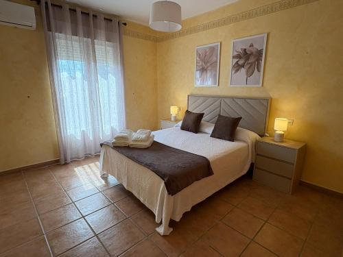 a bedroom with a bed and a large window at Casa Tío Tato , cerca de Puy du Fou y Toledo in Polán