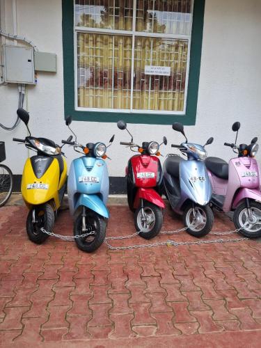 three scooters parked outside of a building at Wings Hotel & Hostel in Trincomalee