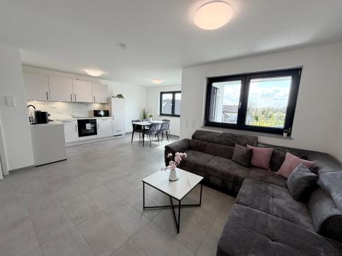 a living room with a couch and a table at BILEANCA - Neubau-Ferienwohnungen Rheinhausen Europa-Park in Rheinhausen