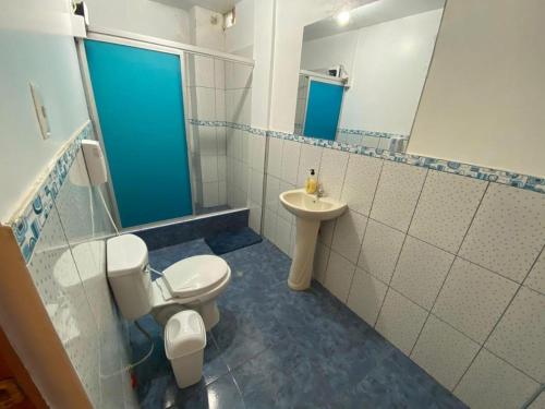 a bathroom with a toilet and a sink at Hospedaje Los Pecanos in Ica