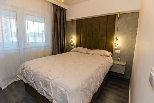 a bedroom with a large bed with a wooden headboard at Old Town Luxury 1 in Târgovişte