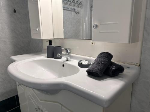 a bathroom sink with a black towel on it at Airport Suites Michelle in Spata