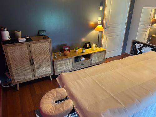 a bedroom with a large bed and a table with a bed sqor at La Chambre de Kerly in Pléguien