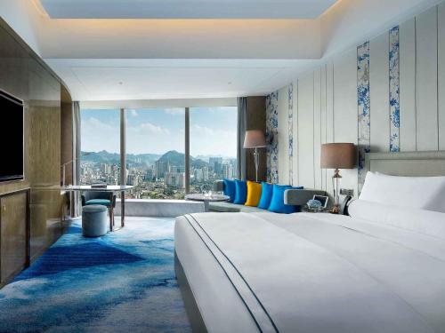 a hotel room with a large bed and a large window at Sofitel Guiyang Hunter in Guiyang