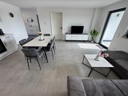 a living room with a couch and a table at BILEANCA - Neubau-Ferienwohnungen Rheinhausen Europa-Park in Rheinhausen