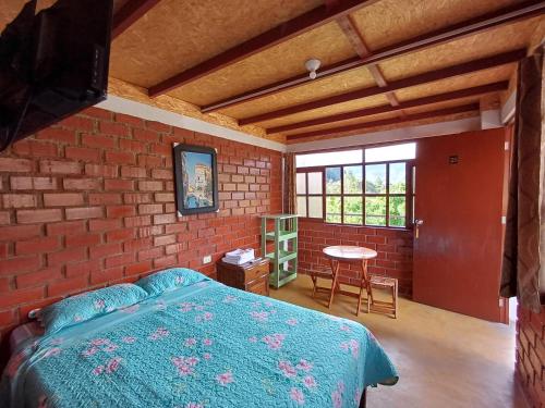 a bedroom with a bed and a brick wall at Casa Hospedaje el Prado Eco turismo in Oxapampa