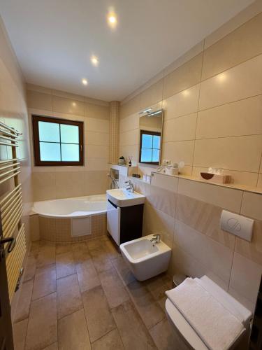 a bathroom with a tub and a toilet and a sink at Jezírko lesní restaurant & penzion in Jáchymov