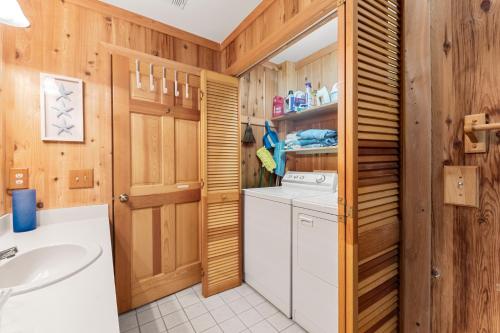 a bathroom with a washer and dryer and a sink at Happy Ours in Corolla