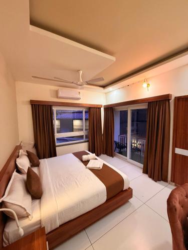 a bedroom with a large bed and a large window at Diga Vista Lake View 4BHK Swimming Pool Cottage Munnar in Munnar
