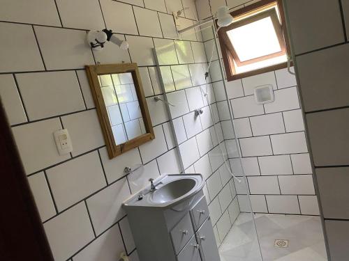 a small bathroom with a sink and a window at Pousada Cantinho da Montanha in Visconde De Maua