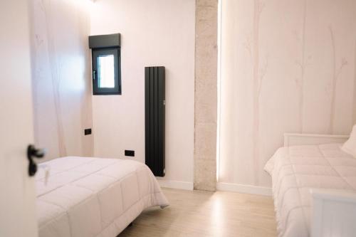 a room with two beds and a mirror on the wall at Casa Deitania I in Caravaca de la Cruz