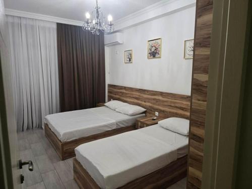 a hotel room with two beds and a chandelier at Gurgen Cottage in Ureki