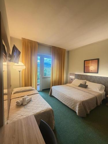 a hotel room with two beds and a window at Hotel Palombella & Restaurant in Frosinone
