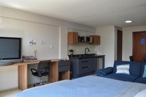a bedroom with a bed and a desk with a television at Centro Histórico Hermosos Departamentos, Casas Freda in San Luis Potosí