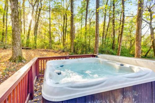 a jacuzzi tub on a deck in the woods at Eliza Cabin Nature Nested Tiny Cabin W Hot Tub in Chattanooga