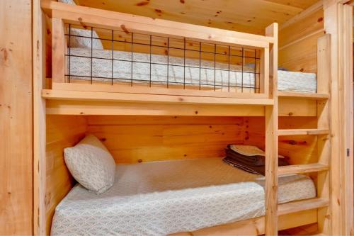 a bedroom with two bunk beds in a wooden cabin at Eliza Cabin Nature Nested Tiny Cabin W Hot Tub in Chattanooga