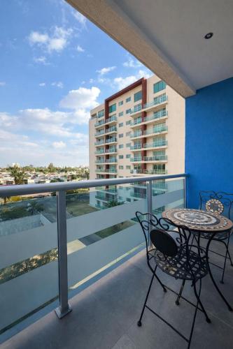 a balcony with a table and chairs and a building at Cozy Loft with Air Conditioning and WiFi near Poliforum Leon Gto in León