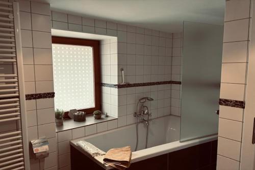 a bathroom with a bath tub and a window at Ferienparadies in der Vulkaneifel in Roth