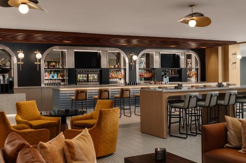 a bar in a hotel room with bar stools at Sheraton Hartford Hotel at Bradley Airport in Windsor Locks