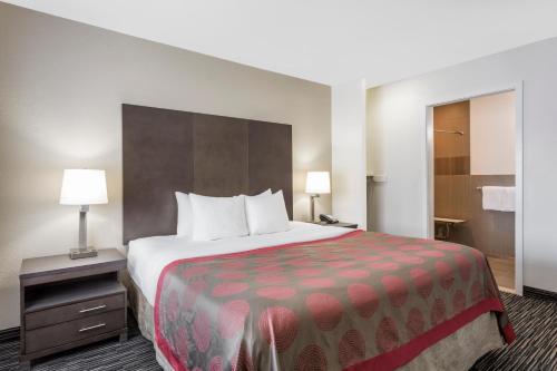 a hotel room with a large bed and two lamps at Ramada by Wyndham Monterey in Monterey
