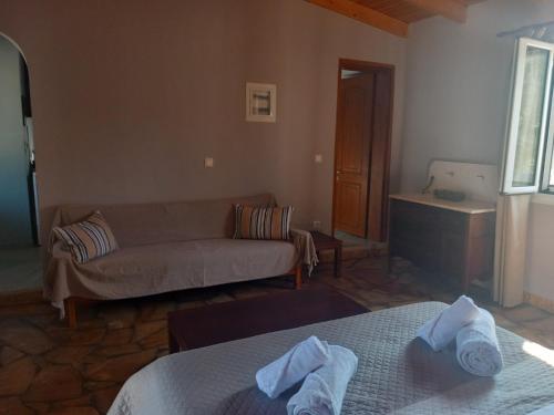 a living room with two beds and a couch at Epicurus beach cottage in Kánalos