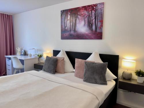 a bedroom with a bed with a painting on the wall at Prime Host Sophie Deluxe Apartment in Karlsruhe