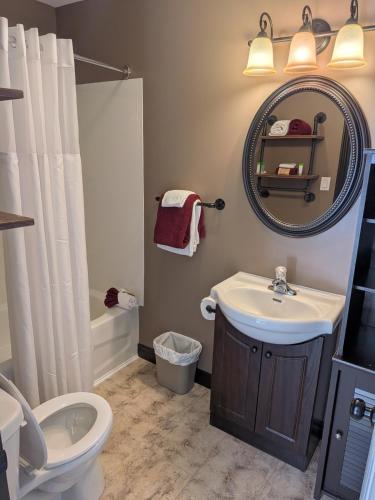 a bathroom with a sink and a toilet and a mirror at Beaver Motel in Wawa