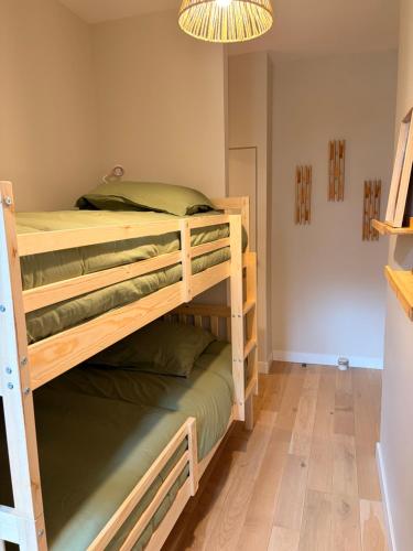 a bedroom with two bunk beds and a chandelier at Ninon et ses sommets in Cauterets