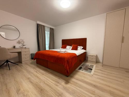 a bedroom with a bed and a desk and a mirror at IDDA Concept 2 dormitoare 2 și living in Târgu-Mureş