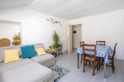 a living room with a couch and a table and chairs at Elegante Attico Fronte Lago - Casa Barozzi in Luino