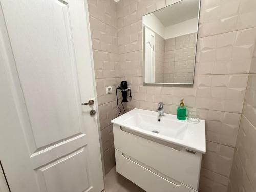 a white bathroom with a sink and a mirror at IDDA Concept 2 dormitoare 2 și living in Târgu-Mureş